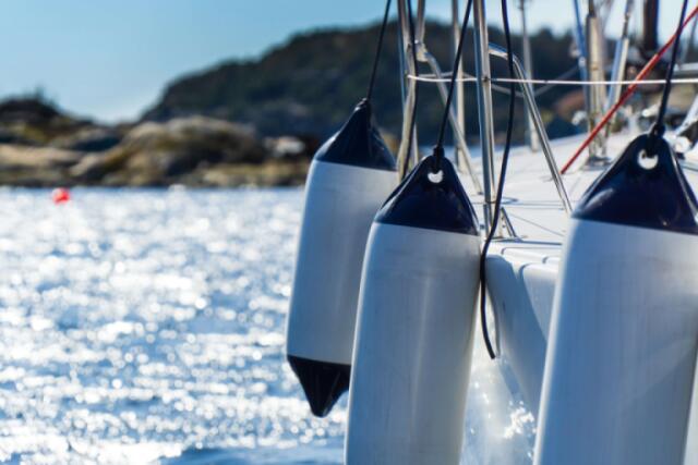 A boat with fenders hanging on the side for protection when mooring.