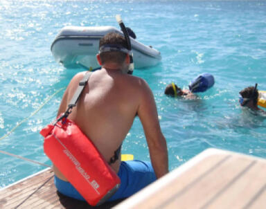 OverBoard 12 Litre Dry Bags being used on the sea between a motor boat and Dinghy to transport personal items safely.